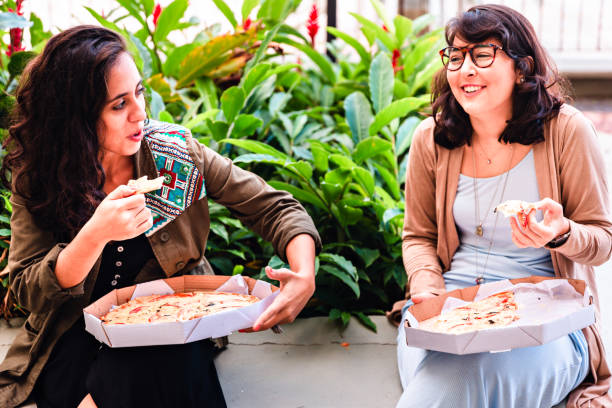 istock Two young friends eating a large pizza each 988089278