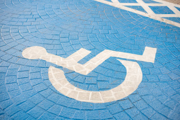 istock Blue handicap wheel chair marking a reserved parking space. 988096766