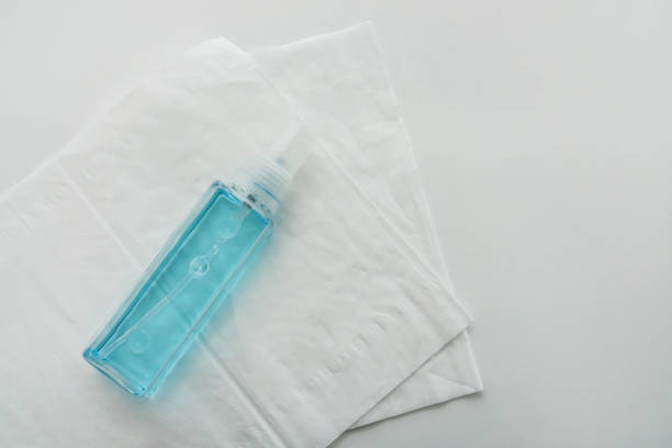 isolated alcohol bottle with tissue paper sheet for health sanitary stock photo