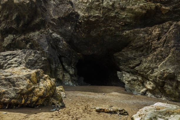 Merlin's Cave from the beach The Entrance to Merlin's Cave under Tintagel, Cornwall, England. cave stock pictures, royalty-free photos & images