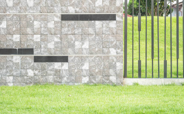 istock Closeup surface brick marble stone wall with green grass texture background 988100418