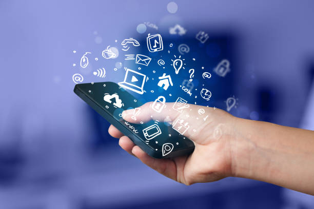 istock Hand holding smartphone with media icons and symbol 988138672