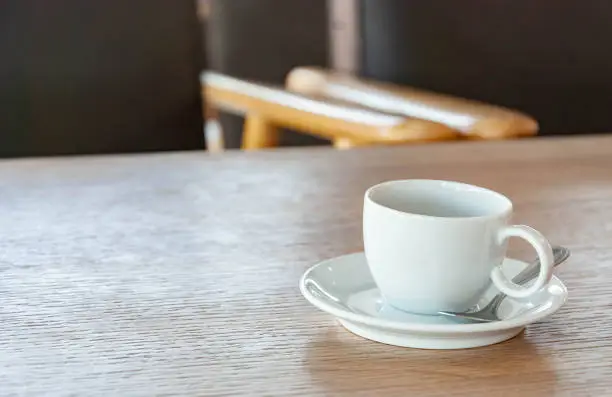 Cup of coffee is placed on a wooden table.