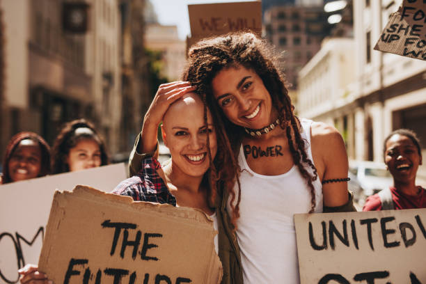 istock Happy women with placards protesting outdoors 988148704