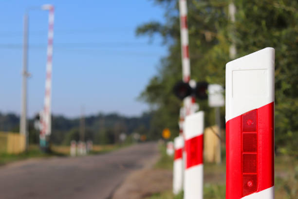 znaki drogowe na przejeździe kolejowym z barierką. organizacja systemu transportowego kraju europejskiego. czerwona biała kolorystyka antycypacyjnej mgły. bezpieczeństwo ruchu drogowego i kolejowego. - anticipatory zdjęcia i obrazy z banku zdjęć