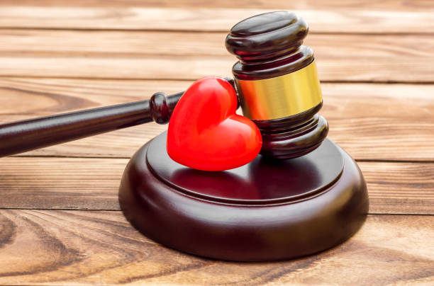 istock Gavel with red heart on wooden table. Close up. 988153524