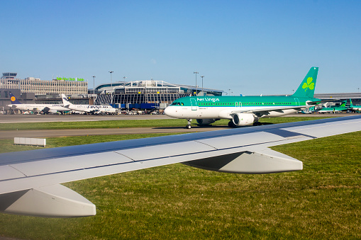 Swords, Ireland. Views of Irish fields, Dublin Airport and an Aer Lingus aircraft from an airplane window, on a sunny spring day