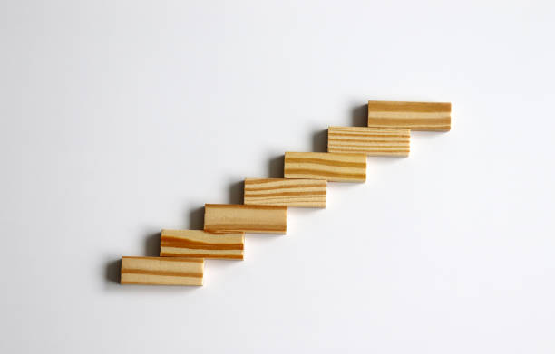 Seven wooden blocks stacked in the shape of a staircase. stock photo