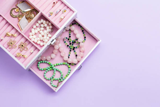 Open jewelry box with neclaces, earrings and rings on pastel background. Top view woman beauty accessories flat lay on pastel background. Fashion or beauty blogger concept. Top view jewelry box photos stock pictures, royalty-free photos & images