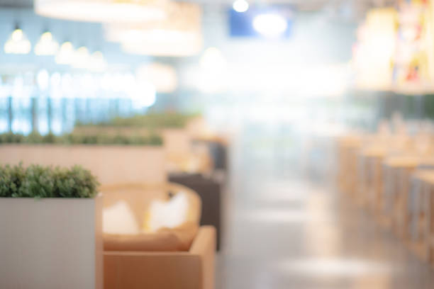 Abstract blurred restaurant background. Blurry cafe or coffee shop with dining tables, chairs and other decorations. Blur backdrop for design element. Food and beverage concept.