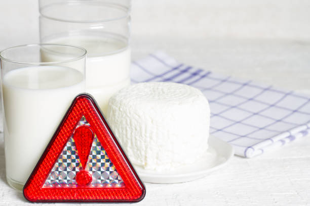 Lactose intolerance with milk dairy product and warning sign concept Lactose intolerance with milk dairy product and warning sign concept closeup lactose fermentation stock pictures, royalty-free photos & images
