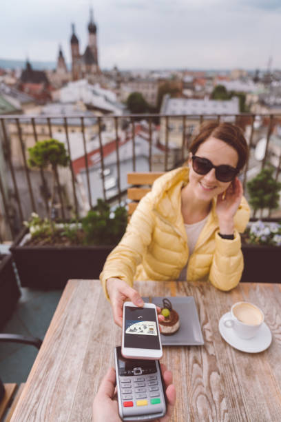 istock Woman in Krakow old town using digital wallet for mobile payment 988201758