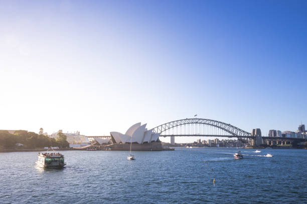 blick auf das wahrzeichen von sydney, opera house und harbour bridge sind eines der berühmtesten orte der welt. australien: 02.08.18 - sydney harbor australia financial district cruise ship stock-fotos und bilder