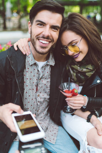 istock Couple at sidewalk cafe paying contactless 988202182