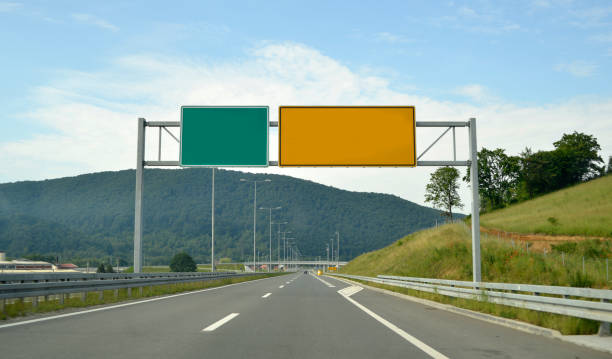 istock Yellow and green board, for direction information, above the highway 988206822