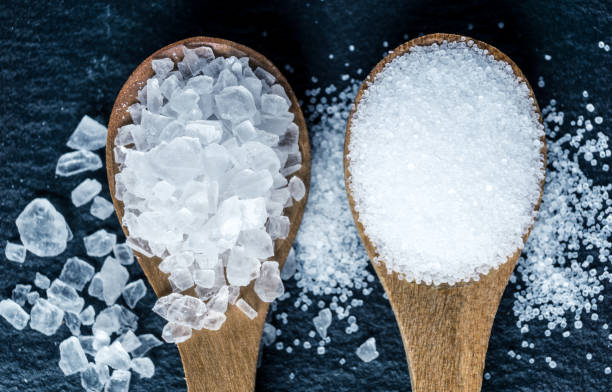 istock Different types of salt. Top view on two wooden spoons 988208760
