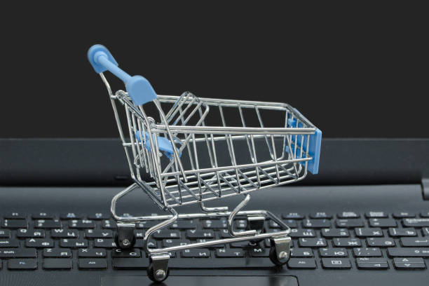 istock Small grocery cart on the laptop keyboard. Concept 988213930