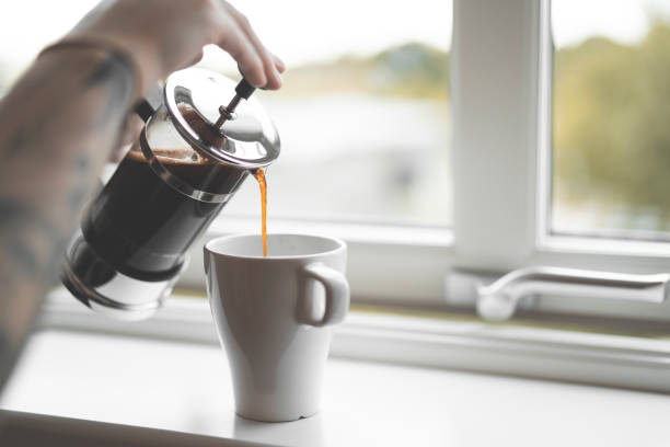 istock Pouring Coffee from French Press on Window Sill 988217626