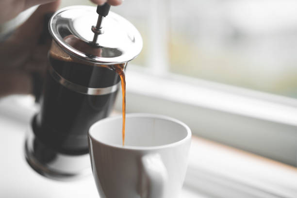 istock Pouring Coffee from French Press on Window Sill 988217632