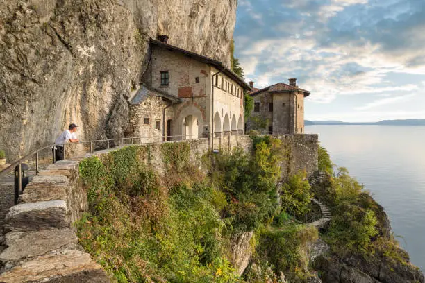Photo of Ancient monastery on lake Maggiore, north Italy. Picturesque view of Hermitage of Santa Caterina del Sasso (XIII century), one of the most fascinating historical sites of lake. External facade