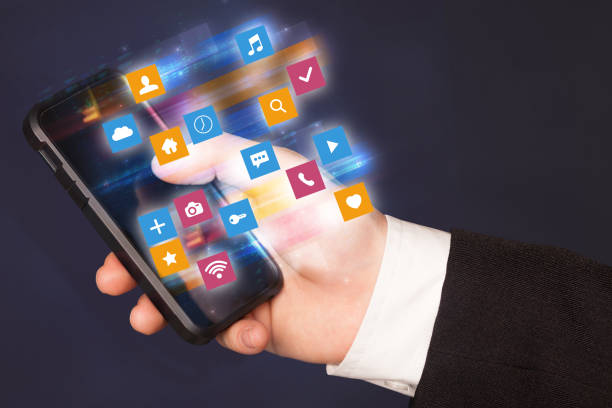 istock Hand using phone with colorful application icons and symbols concept 988229536