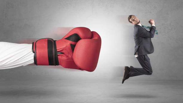 istock Businessman gets a hit from a giant hand 988235870