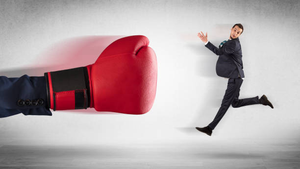 istock Big hand boxing little businessman 988236612