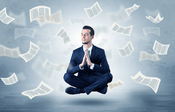 istock Businessman meditating with flying paper concept 988239320
