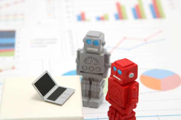 istock Robots or artificial intelligence and laptop on graphs and charts. Concept of artificial intelligence. 988247548