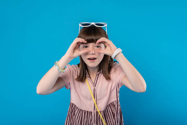 istock Content schoolgirl holding imaginary binocular 988251716