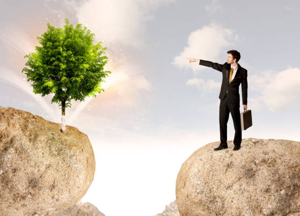 istock Businessman on rock mountain with a tree 988291806