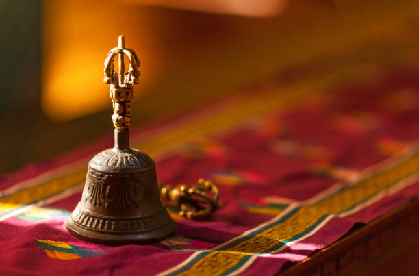 Hand bell, in sunlight inside a temple Ritual hand bell in the Buddhist temple as the enlightenment symbol, has got to a light beam. kurma stock pictures, royalty-free photos & images