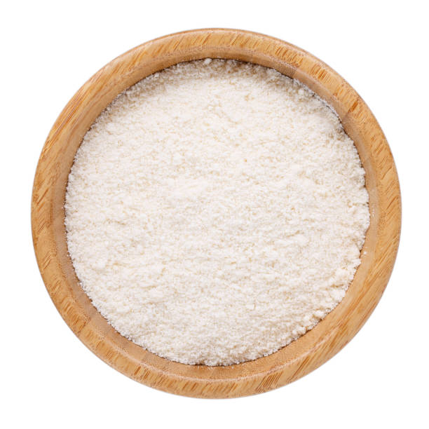 istock Coconut flour in wooden bowl isolated on white. Top view. 988321380