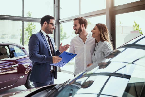 pareja joven compra un coche - vendedor fotografías e imágenes de stock