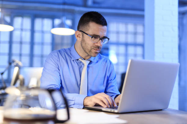 istock Middle aged businessman working late 988322248