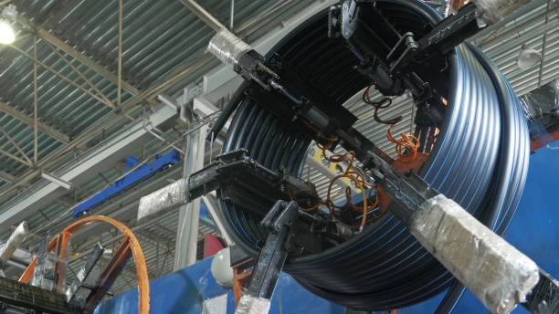 istock Roll threading coil pipe. Manufacture of plastic water pipes factory. Process of making plastic tubes on the machine tool with the use of water and air pressure. 988325270