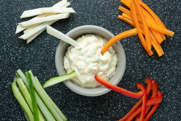 istock Vegetable sticks and dips in bowl. Healthy vegetables and dip snack. 988325288