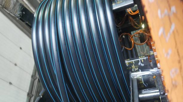 istock Roll threading coil pipe. Manufacture of plastic water pipes factory. Process of making plastic tubes on the machine tool with the use of water and air pressure. 988325382