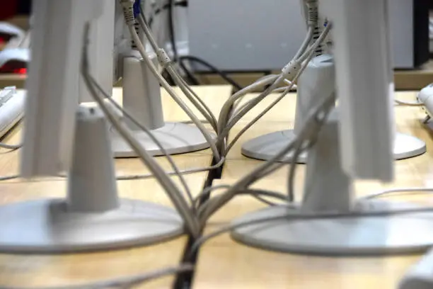 Photo of Computer cables connected with monitors on the office desk
