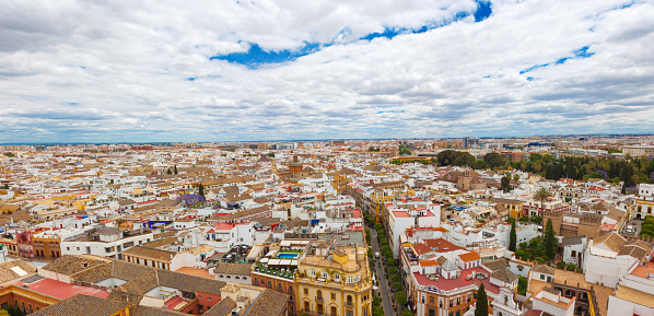 Beautiful panoramic view from the Giralda on the city of Sevilla, Andalusia, Spain. A lot of colored old  spanish houses and blue sky with white clouds
