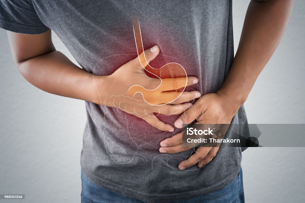 Acid reflux or Heartburn, The photo of stomach is on the men's body against gray Background, Bad health, Male anatomy concept Acid reflux or Heartburn, The photo of stomach and internal organs is on the men's body against gray background, Stomach ache, Bad health, Male anatomy concept. Digestive System Stock Photo