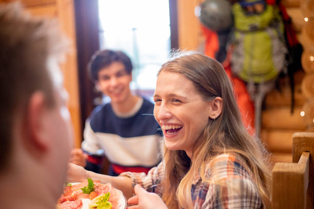 istock Friends Eating Dinner in a Log Cabin 988356566