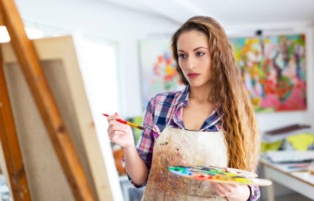 istock Young woman drawing in art studio 988359104