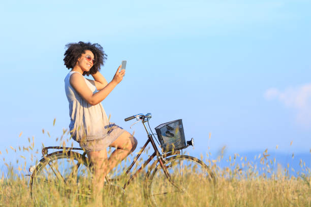istock African woman with bike using smart phone 988367892