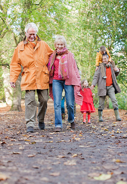 familia caminando al aire libre en otoño - coat grandfather grandchild granddaughter fotografías e imágenes de stock