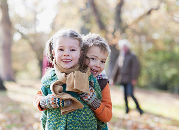frère et sœur se tenant à l'extérieur - smiling little girls little boys autumn photos et images de collection