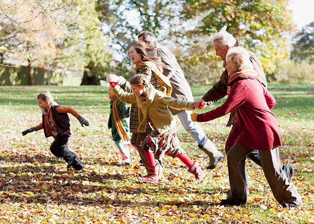 familia corriendo en el parque - coat grandfather grandchild granddaughter fotografías e imágenes de stock