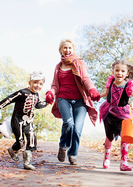 Grandmother running with grandchildren in Halloween costumes  trick or treat photos stock pictures, royalty-free photos & images