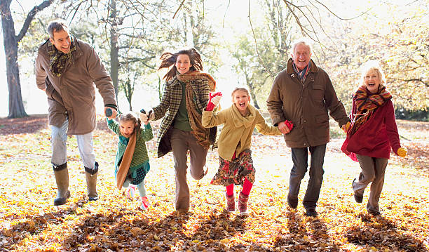 familia corriendo en el parque de otoño - coat grandfather grandchild granddaughter fotografías e imágenes de stock