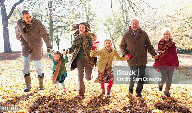 Extended Family Running In Park In Autumn Stock Photo - Download Image Now - Family, Multi-Generation Family, Autumn